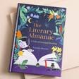 The Literary Almanac: A Year of Seasonal Reading Book on Pink Surface