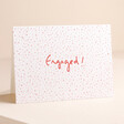 Heather Evelyn Confetti Engagement Card on pink surface