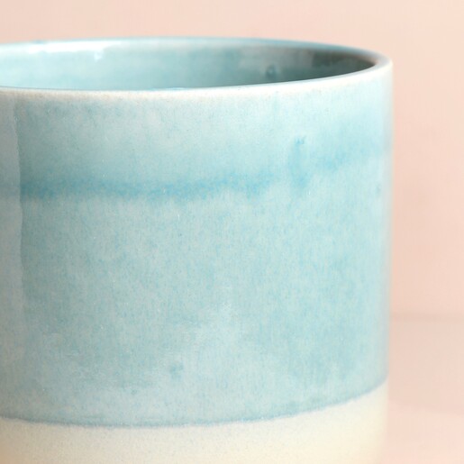 Close up of details on Ivyline Jolie Aqua Matte Reactive Standing Planter against beige backdrop