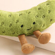 Close Up of Jellycat Amuseable Pickle Soft Toy against beige background