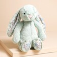 Jellycat Blossom Sage Bunny Little Soft Toy sat on top of raised beige surface