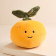 Jellycat Fabulous Fruit Orange Soft Toy on top of raised beige surface