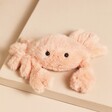 Jellycat Fluffy Crab Soft Toy on top of beige surface