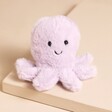 Jellycat Fluffy Octopus Soft Toy on top of beige backdrop