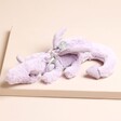 Jellycat Lavender Dragon Bag Charm on Beige Surface