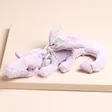 Jellycat Lavender Dragon Bag Charm on Beige Surface