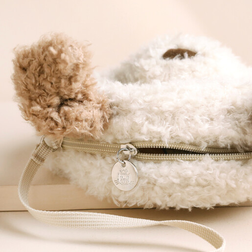 Close up of zip on Jellycat Little Pup Bag against beige backdrop