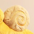 Close up of shell on Jellycat Sandy Snail Soft Toy against beige backdrop