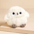 Jellycat Snowy Owling Soft Toy sat on top of beige coloured surface