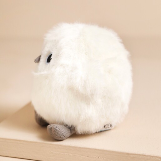 Side of Jellycat Snowy Owling Soft Toy on top of raised beige surface