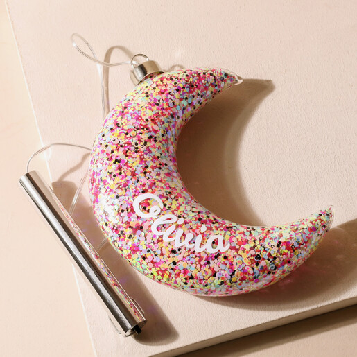 Personalised Hanging Pink Glitter LED Moon Light on Beige Surface With Battery Pack Showing