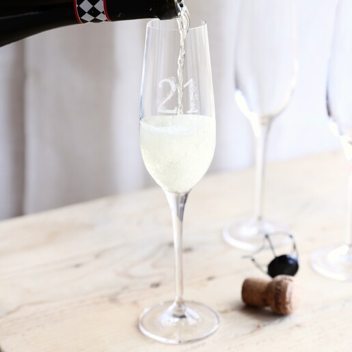 Model pouring champagne inside of Personalised 21st Birthday Champagne Glass in lifestyle shot