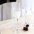 Model pouring champagne inside of Personalised 50th Birthday Champagne Glass in lifestyle shot