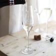 Personalised Name Champagne Glass in lifestyle shot with model pouring champagne inside