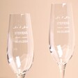 Close up of Set of 2 Personalised Wedding Champagne Glasses against beige coloured background