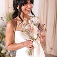Close up of model with the Margot Dried Flower Bridal Wedding Bouquet, laughing