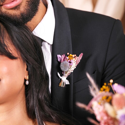 Close up of a model wearing the posy in his suit