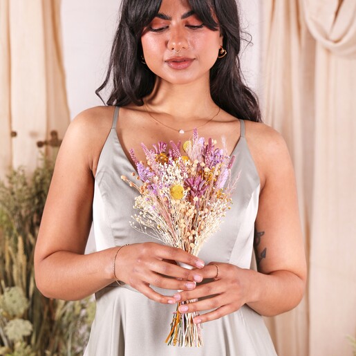A model in a green bridesmaid dress holding the posy
