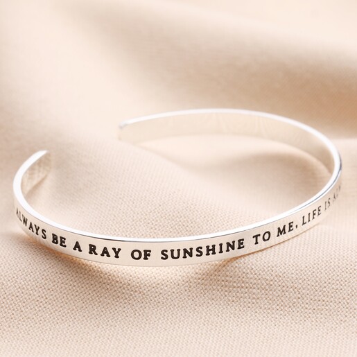 Ray of Sunshine Meaningful Word Bangle in Silver on top of neutral coloured fabric
