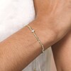 close up of the Crystal Blue and White Beaded Cord Bracelet in Gold on model