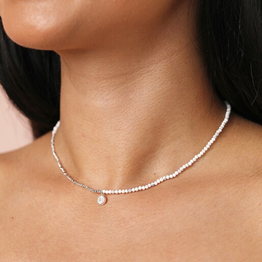Close up of the Daisy Charm White & Silver Beaded Necklace on model