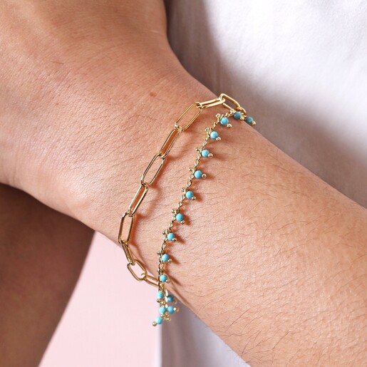 Close up of Teal Stone Droplet and Cable Chain Layered Bracelet in Gold on model
