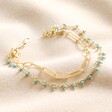 Teal Stone Droplet and Cable Chain Layered Bracelet in Gold on top of beige coloured fabric