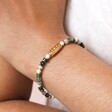 close up of the Gold Stainless Steel Green Semi-Precious Stone Beaded Bracelet on a model