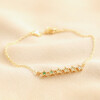 Green Ombre Crystal Star Bar Bracelet in Gold on top of beige coloured fabric