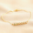 Green Ombre Crystal Star Bar Bracelet in Gold on top of beige coloured fabric