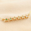 Close up of bar charm on Green Ombre Crystal Star Bar Bracelet in Gold against neutral coloured material