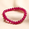 July Ruby Jade Birthstone Semi-Precious Stone Beaded Bracelet on top of neutral coloured material