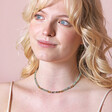 Green Semi-Precious Stone Heishi Beaded Necklace in Gold on model looking outwards against pink toned backdrop