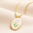Meaningful Word Enamel Flower Pendant Necklace in Gold on top of beige coloured fabric