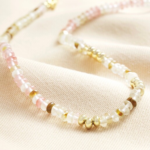 Close up of Mixed Rondelle Stone Beaded Necklace in Gold against beige coloured backdrop