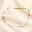 Mixed Rondelle Stone Beaded Necklace in Gold laid on top of beige coloured fabric