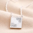 Close up of Sunbeam Square Pendant Necklace in Silver on top of beige coloured fabric