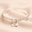 You Are Loved Meaningful Word Bangle in Silver on top of beige coloured fabric
