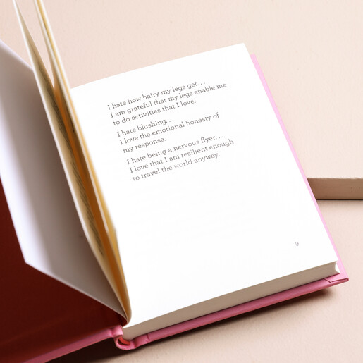 Open pages of The Little Book of Self Love on Beige Surface