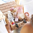 Model holding Build Your Own Bridesmaid Gift Hamper with wicker hamper basket open on lap