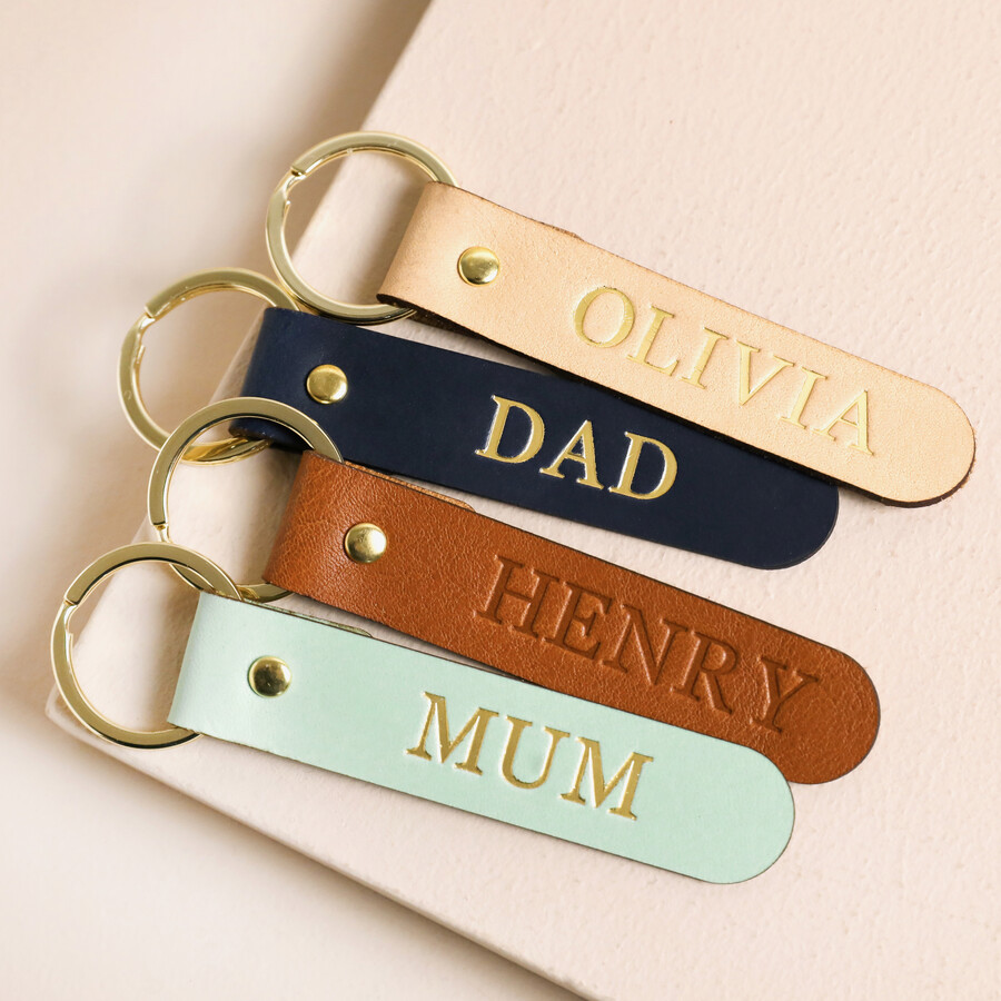 Personalised Name Leather Keyrings laid on top of beige coloured fabric