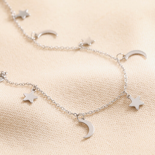 Stainless Steel Star and Moon Charm Necklace against beige coloured fabric