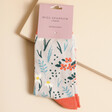 Miss Sparrow Bamboo Floral Meadow Socks in Packaging on Beige Surface