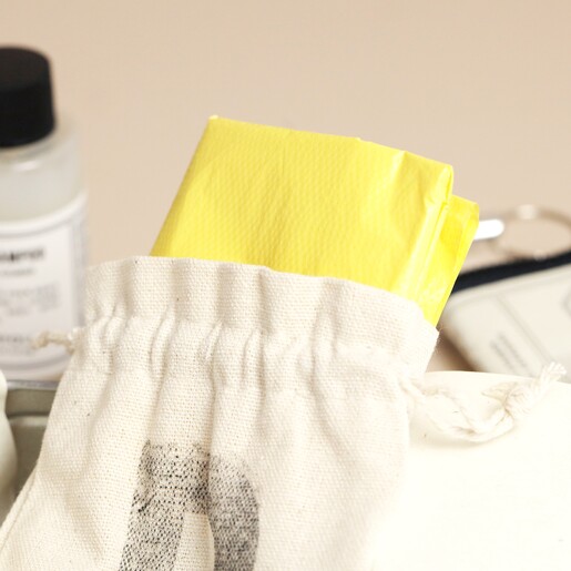 Biodegradable poo bags inside of drawstring cotton pouch from Norfolk Natural Living Dog Walking Kit 