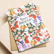 Ohh Deer Happy Anniversary Floral Greetings Card on top of envelope on beige Surface