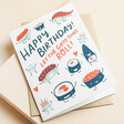 Ohh Deer Let the Good Times Roll Sushi Birthday Card on top of brown kraft envelope with beige background