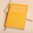 Papier Follow The Sun Travel Journal on top of beige coloured background