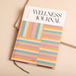 Papier Happy Stripes Wellness Journal on top of beige coloured backdrop