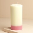 The Recycled Candle Company Pink Jasmine and Pear Pillar Candle on raised surface against beige background