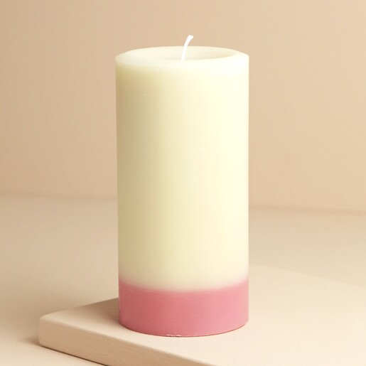 The Recycled Candle Company Pink Jasmine and Pear Pillar Candle on raised surface against beige background